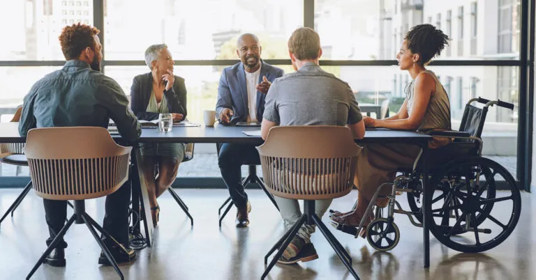 Employees sit around a conference table to develop a business continuity plan