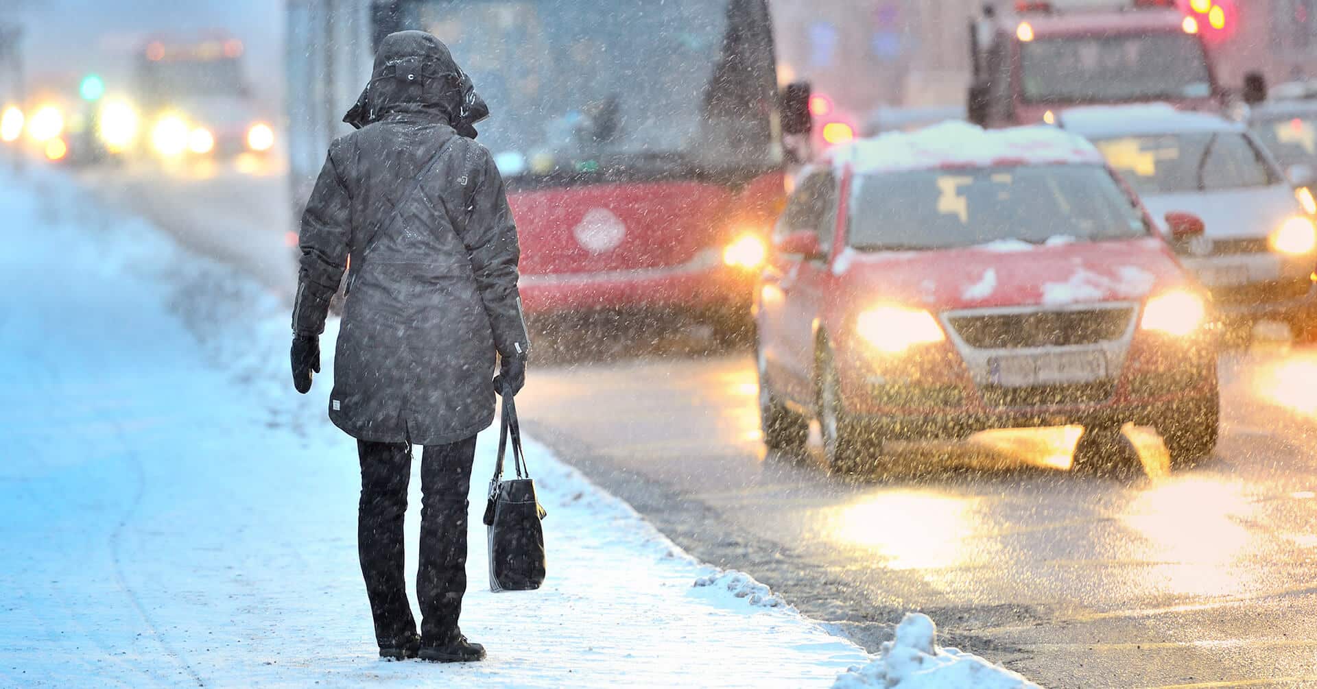 a white van drives under a bridge in extremely snowy conditions