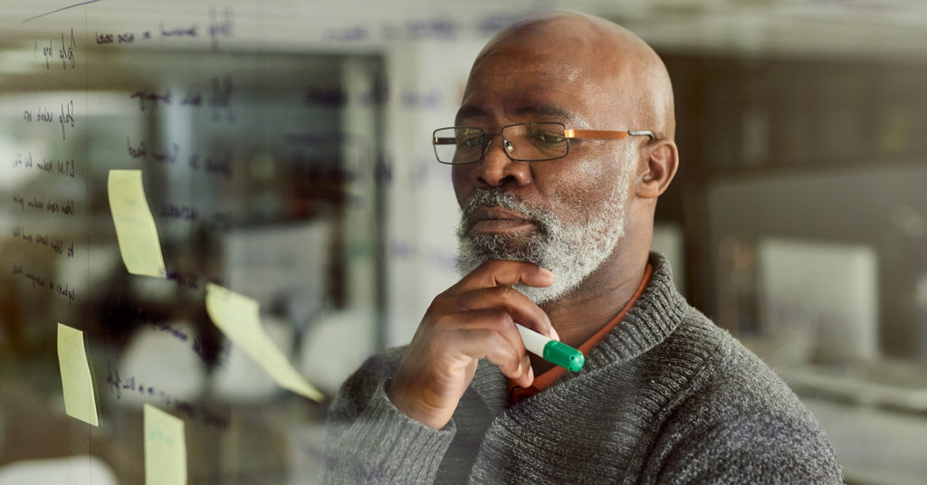 Man stroking his beard while pondering the potential threats to his employees and business