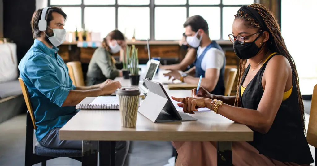 Employees working at tables wearing masks