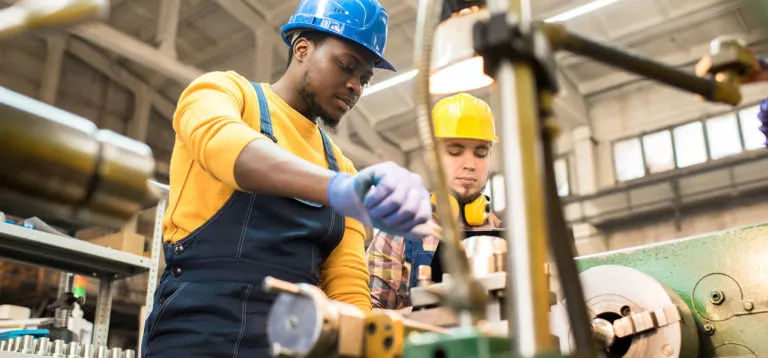 two men in hard hats operating machinery