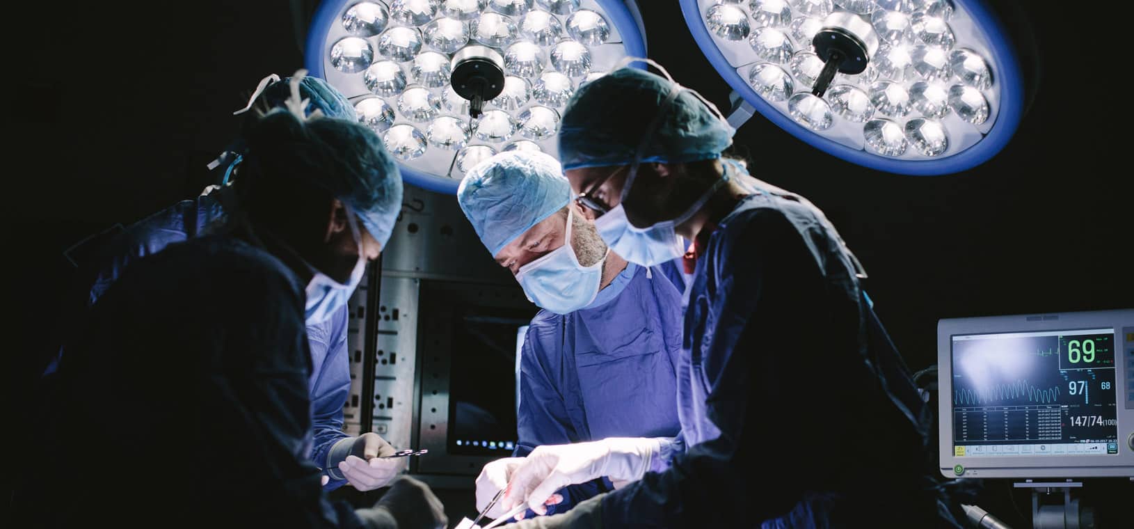surgical team in surgical garb under operating lights