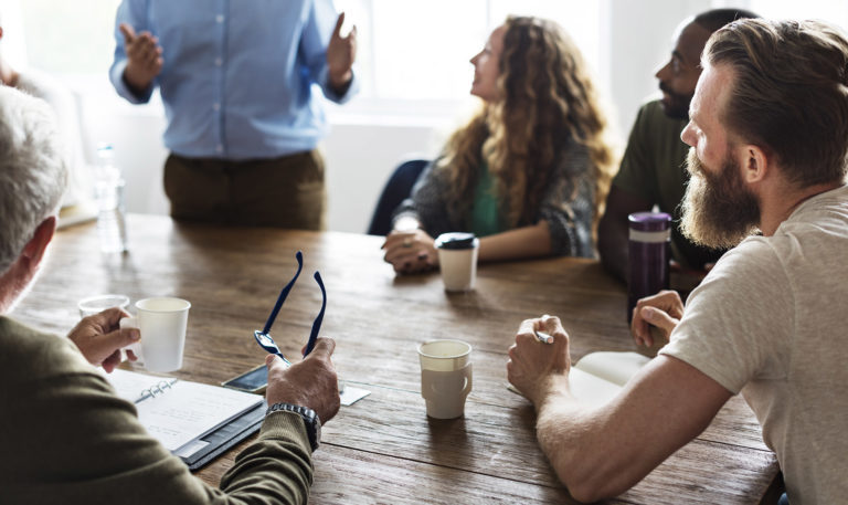 People gathered around an office table for a meeting