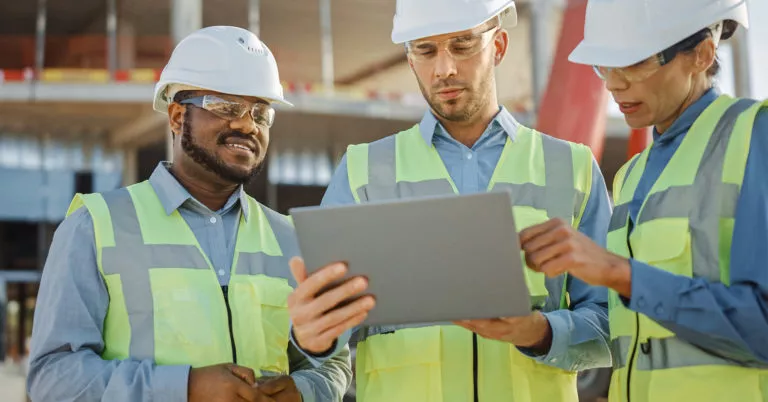 Three construction workers reviewing plans.