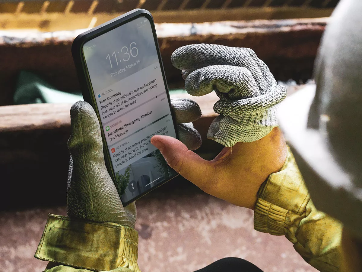 work gloved hands holding a smart phone