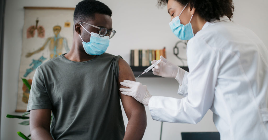 A man getting a vaccine from a doctor