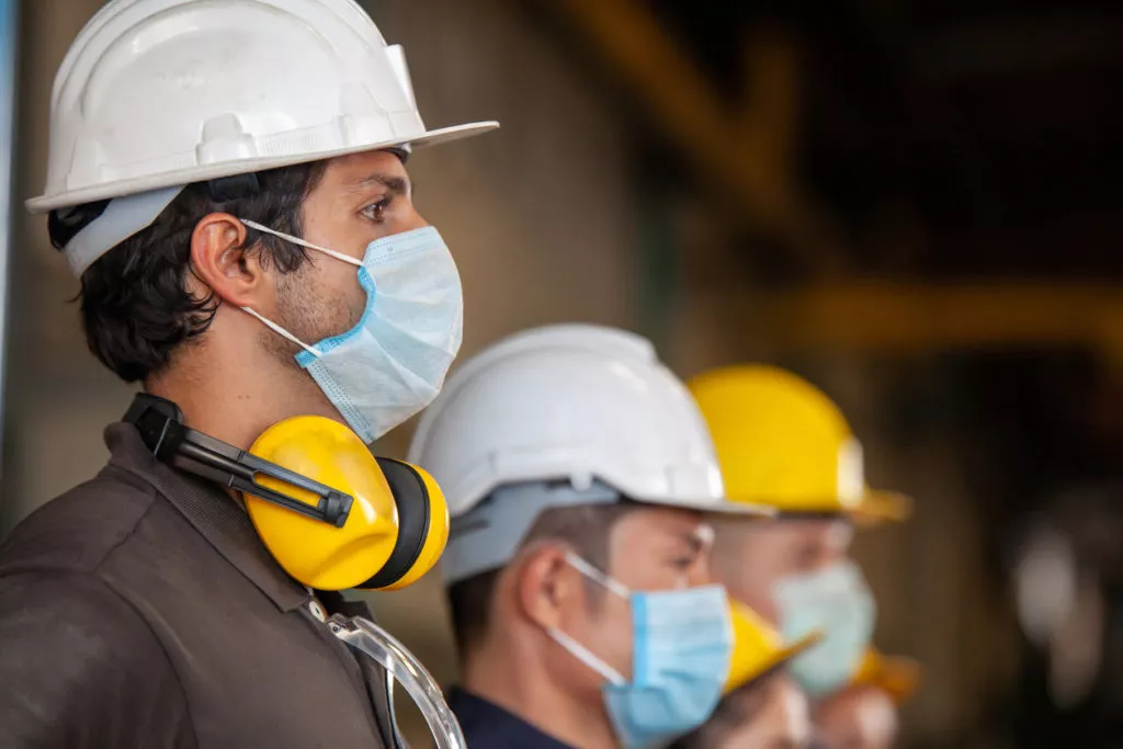 Workers wear protective face masks