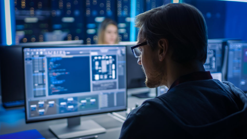 Male IT Programer Working on Desktop Computer in Data Center