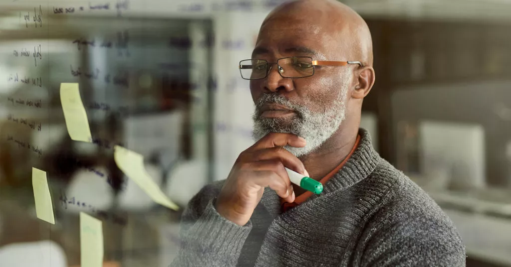 Man looking at whiteboard making crisis management plan