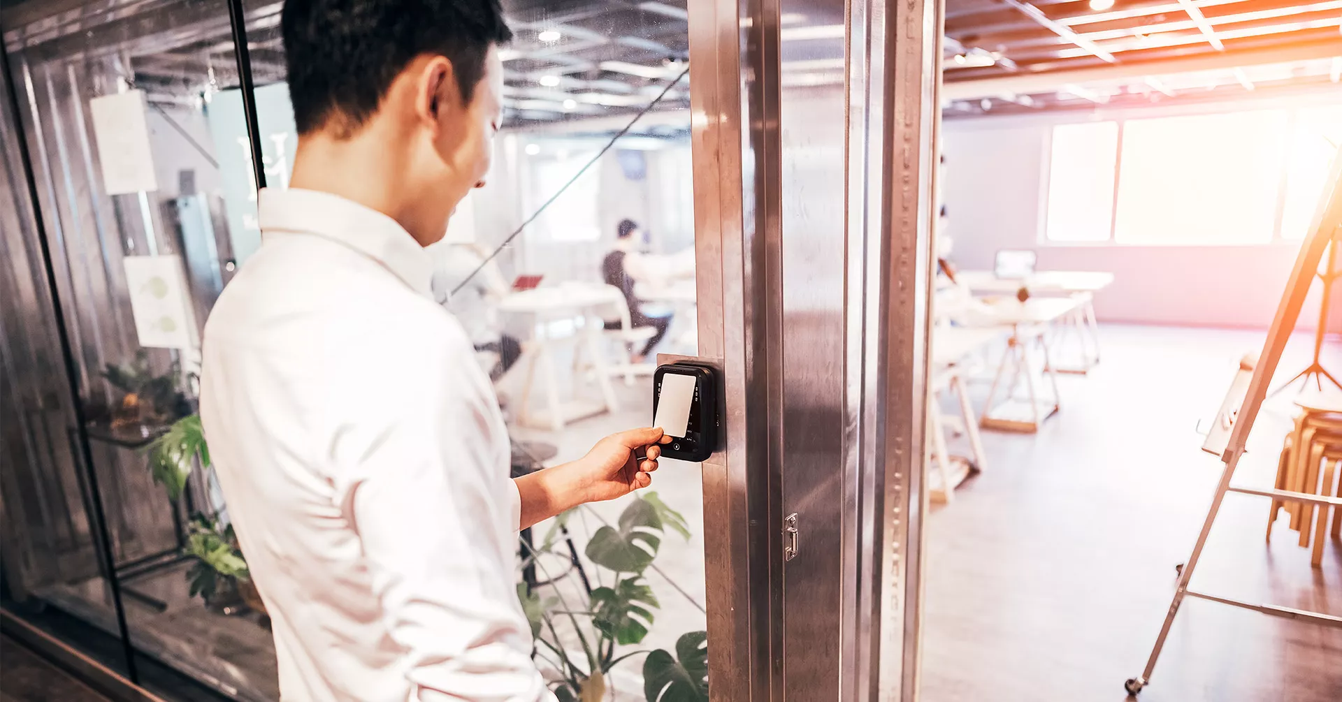 A person using an access card to get into an office room—a target hardening technique