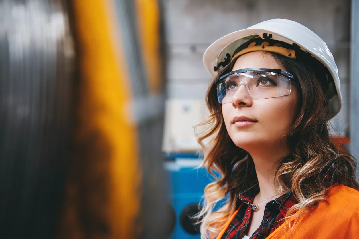 Portrait of young beautiful engineer woman working in factory building.