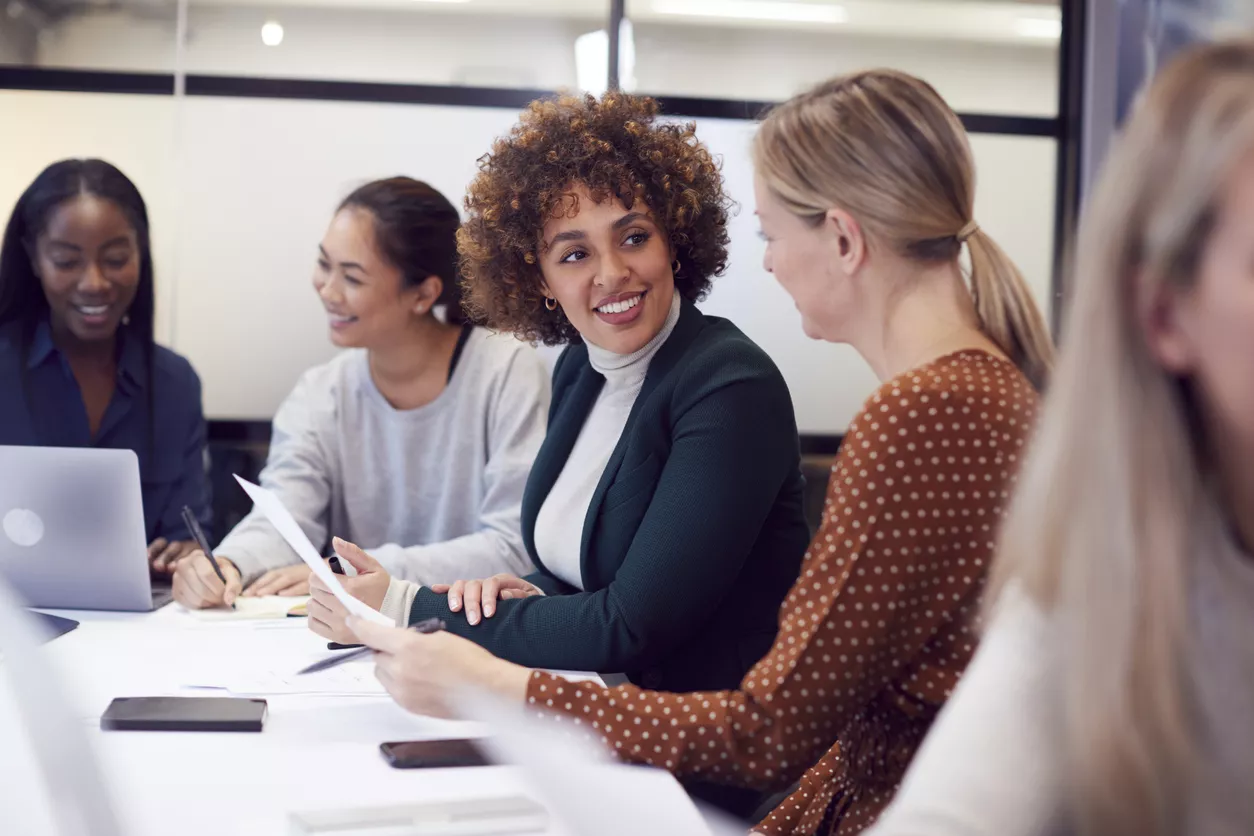 Group Of Businesswomen Collaborating In Creative Meeting Around Table In Modern Office