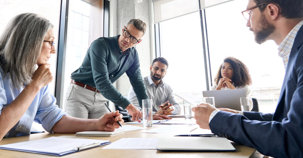 A team of leaders plan business resilience strategies at a conference table.