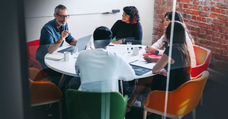 A team gathers around a conference table to discuss safety topics.