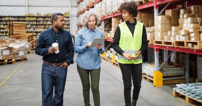 Three warehouse employees discuss safety plans