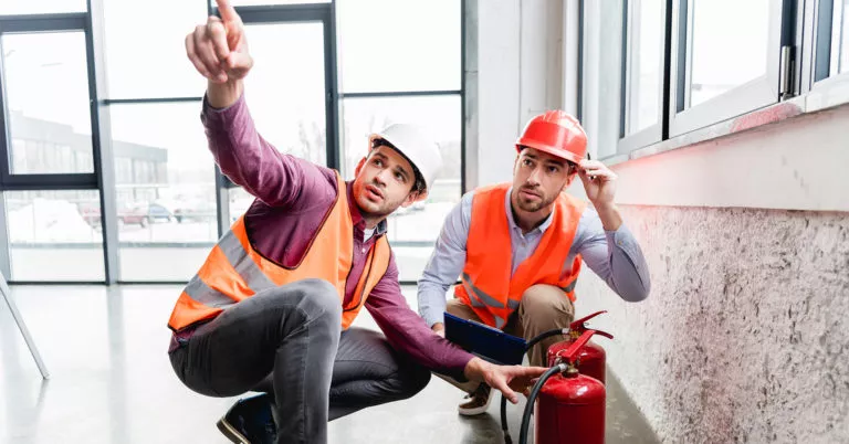 Workers inspect fire safety systems as part of a fire prevention plan