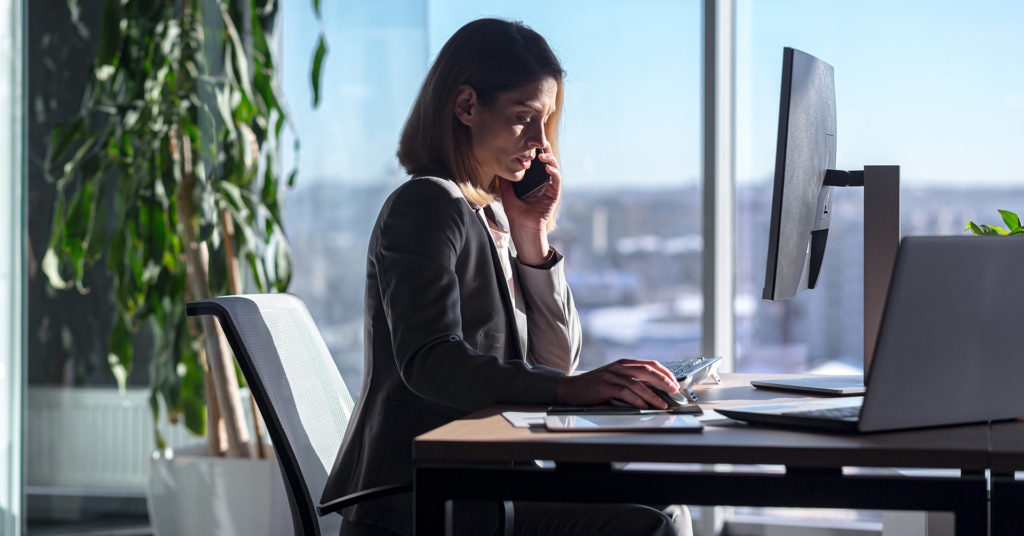 Employee sits at a computer, researching potential threats to inform business preparedness efforts.