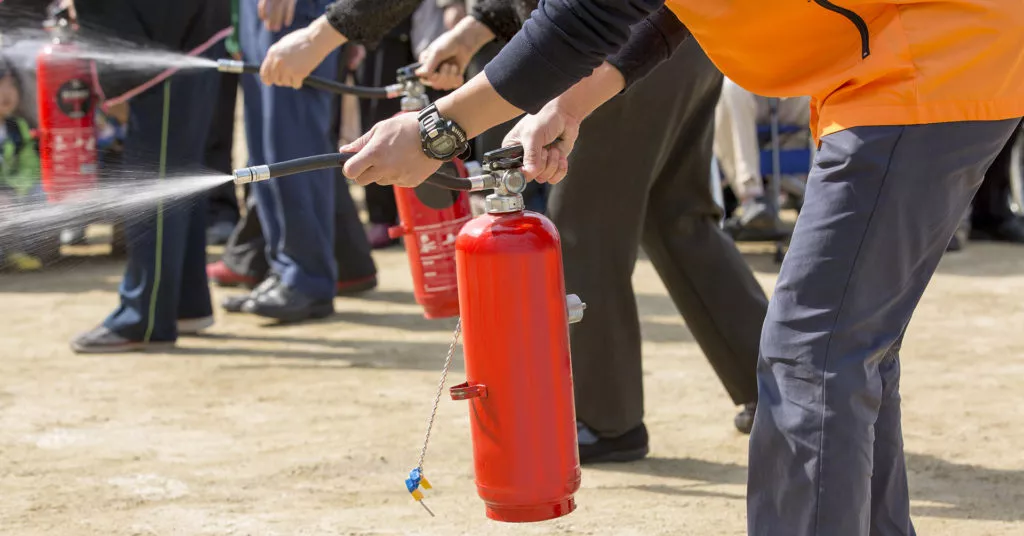Workers practice using fire extinguishers