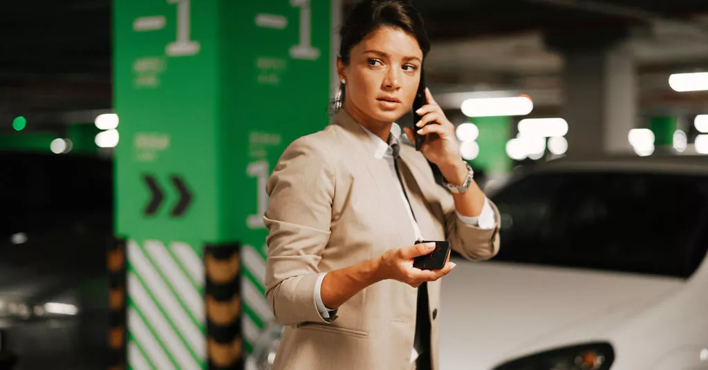 Woman scans a parking lot while on the phone