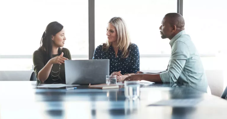 employees at table discuss an emergency action plan