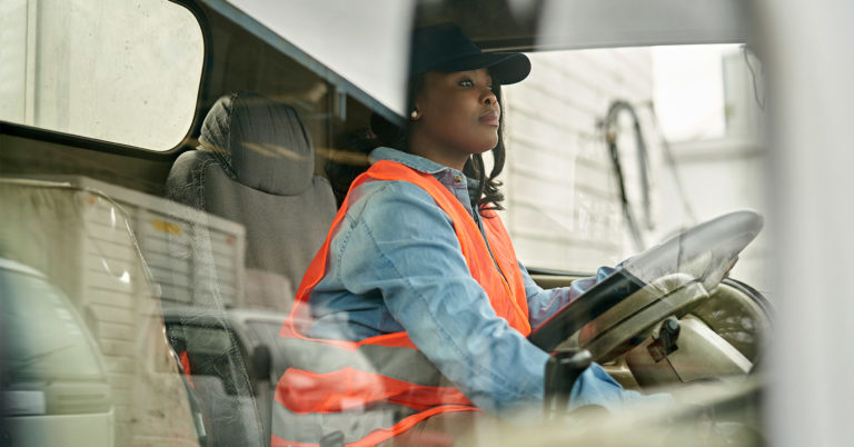 Worker in orange vest drives truck