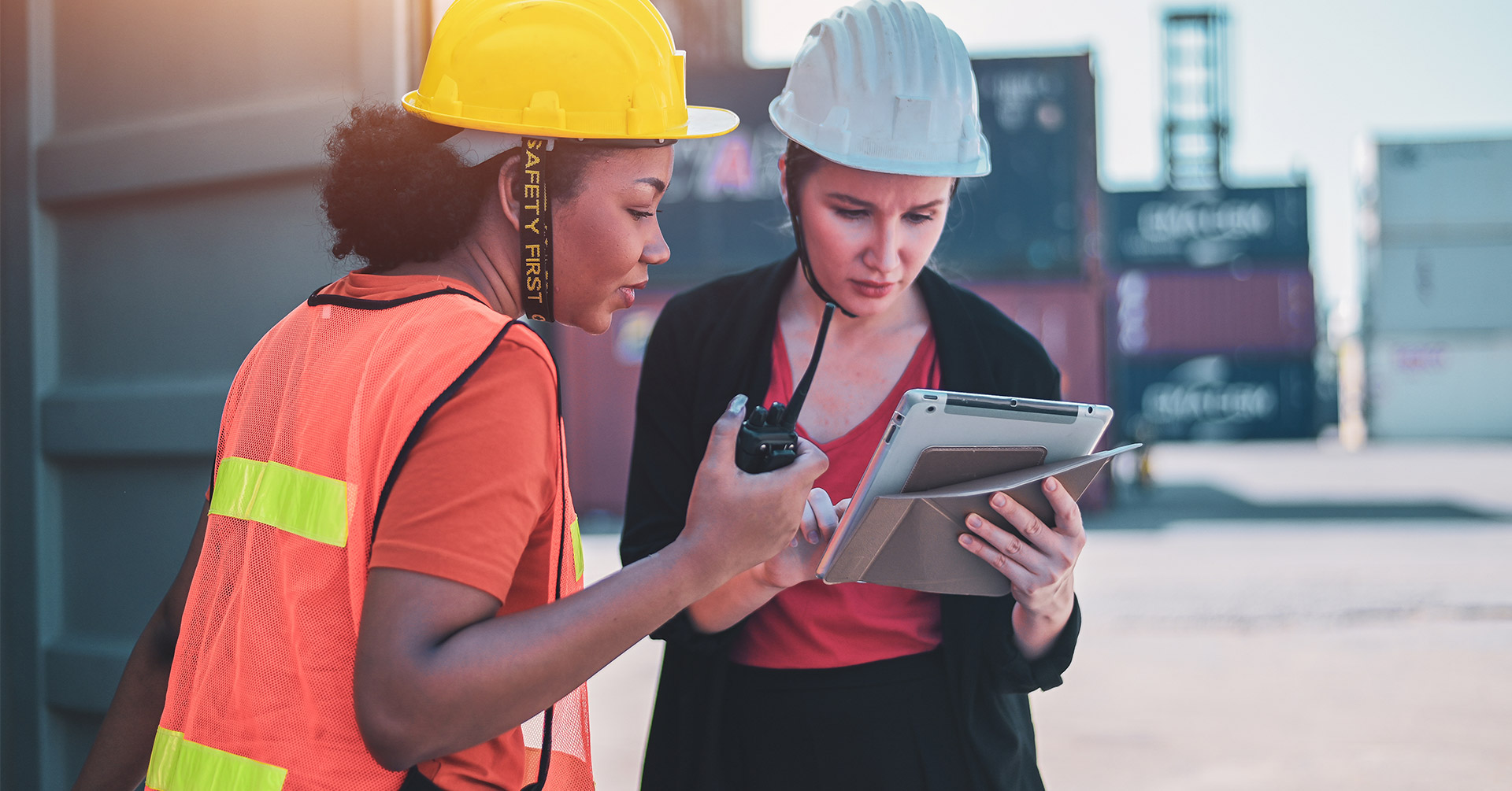 Two workers looking at a clipboard with safety communications on it