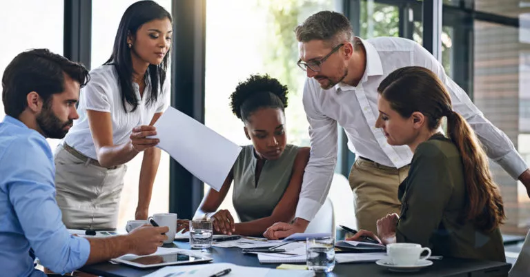 A team collaborates in a conference room to create a risk mitigation plan.