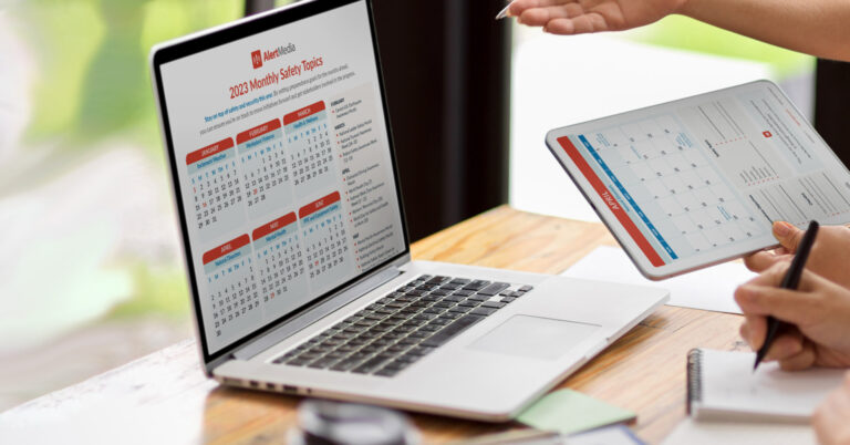 Employee reviews safety calendar on laptop and tablet