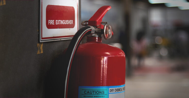 A fire extinguisher mounted on the wall for workplace fire safety