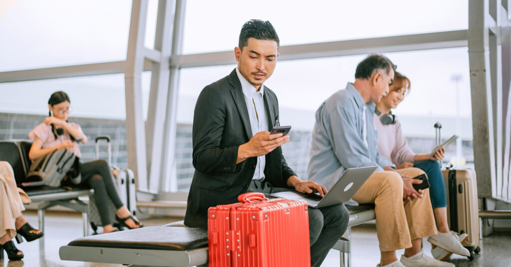 Worker checking phone at airport gate