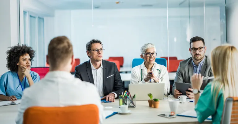 Workers at conference table discuss emergency roles