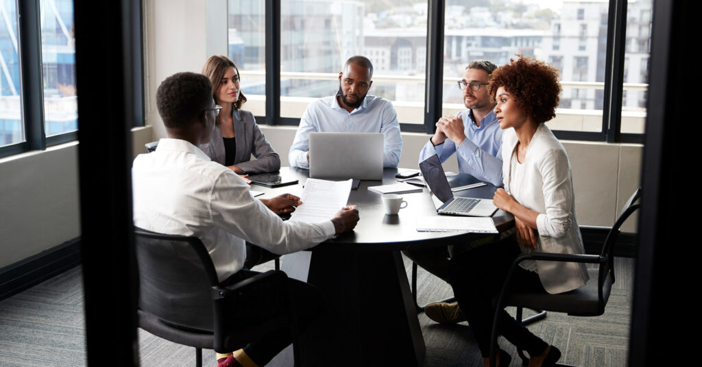 Workers discuss ISO 22301 at a conference table