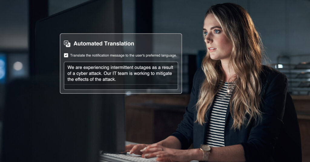 Woman works on a desktop computer, typing an emergency notification, which is visible in the foreground of the image, showing a checkbox to automatically translate the message in recipients' preferred languages