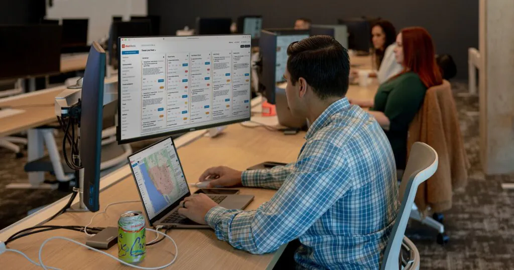 An AlertMedia global intelligence analyst works at a computer in the Command Center, monitoring threats to customers