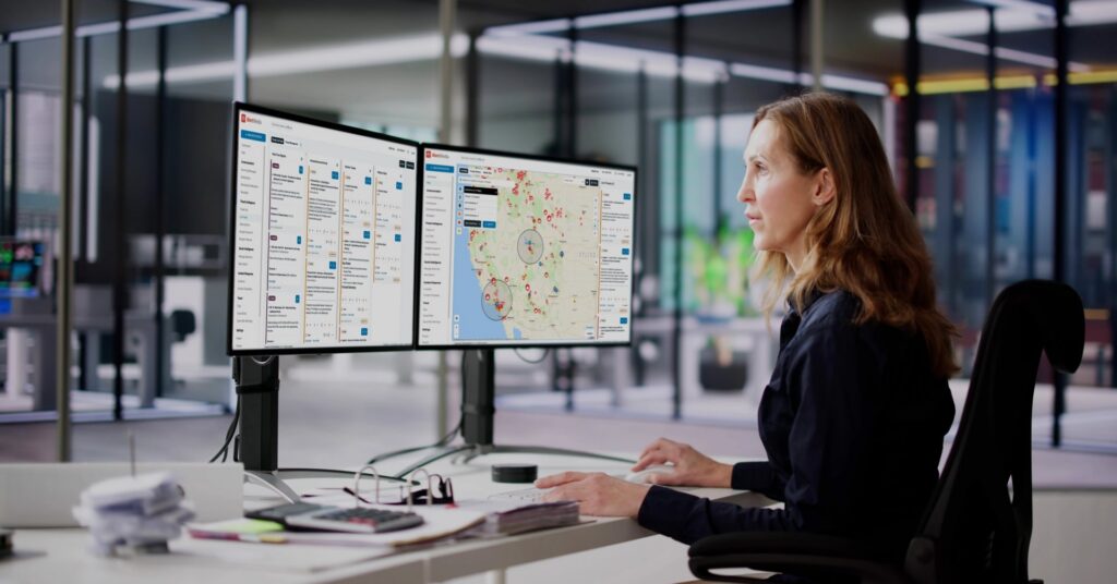Security operations professional monitoring incidents and threat intelligence on dual AlertMedia platform dashboards.