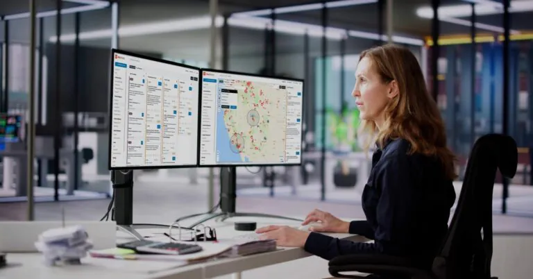 Security operations professional monitoring incidents and threat intelligence on dual AlertMedia platform dashboards.